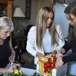 From left to right: Julie Reece-DeMarco and her daughters Natalie and Sophia DeMarco organize and pack supplies for Afghan families coming to the Pacific Northwest area. Alex Bruell/Sound Publishing