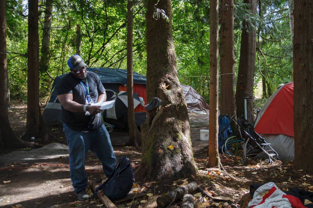 Homelessness Outreach Program Coordinator Kent Hay delivers mail to a resident of a camp on Aug. 27, 2021. Photo by Henry Stewart-Wood/Sound Publishing
