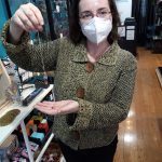 Juliana Solovjev, co-owner of Aura Song Gifts, demonstrates the use of a pendulum, one of the metaphysical tools available at her boutique. Photo by Robert Whale, Auburn Reporter