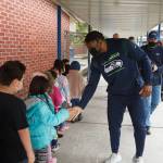 Photo by Henry-Stewart-Wood
Seahawks linebacker Jordyn Brooks high-fives kids at Chinook Elementary School on their way to class on Tuesday, Mar. 8, 2022.