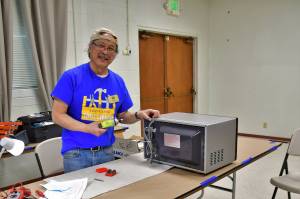Gary Ichinaga, a volunteer fixer at the South King Tool Library, works on a microwave during last weeks repair cafe, an event in which locals can get help repairing their stuff rather than throwing it away. Photo by Bruce Honda.