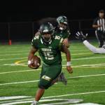 Trojan QB DJ Bielza tries to avoid a defender. Ben Ray / The Reporter