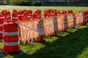 Sixty-one orange traffic barrels were set up April 2, 2024, on the WSDOT front lawn in Olympia. Each cone represents a fallen WSDOT employee killed on the job since 1950 - many in active work zones. The visual display is meant to remind everyone of the importance of slowing down in work zones. Photo courtesy of Washington State Department of Transportation.