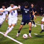 Raven forward Guilexander Barajas plays keep away against Todd Beamer. Photos by Ben Ray / The Reporter