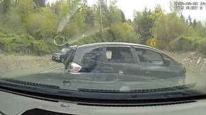 A pursuing officer deployed a PIT maneuver on the Honda Fit, resulting in the vehicle turning sideways onto the side of the road. (Screenshot.)