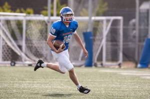 Elijah Baird runs the ball during the Lions scrimmage at Curtis High School. Photo courtesy of Maria Dorsten.