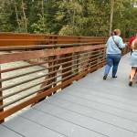 Above, pedestrians try out the new bridge Oct. 1 at Game Farm Park.