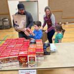 Seth and Katie Price, along with their children Isaac and Brielle, assemble meals-in-a-bag at the Auburn congregation of The Church of Jesus Christ of Latter-day Saints for families in need, as part of a food drive benefiting Vine Maple Place. Courtesy photo