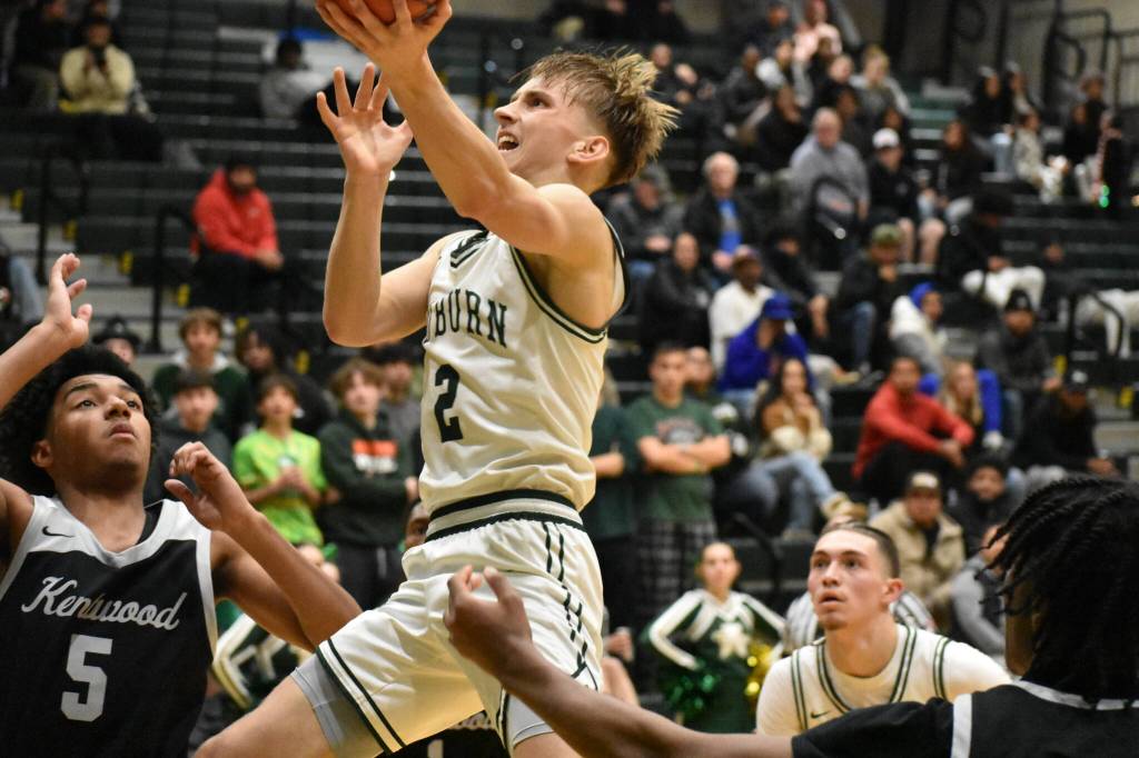 Senior Carter Hansen rises above the Kentwood defense for the lay-in against the Conks. Ben Ray / The Reporter