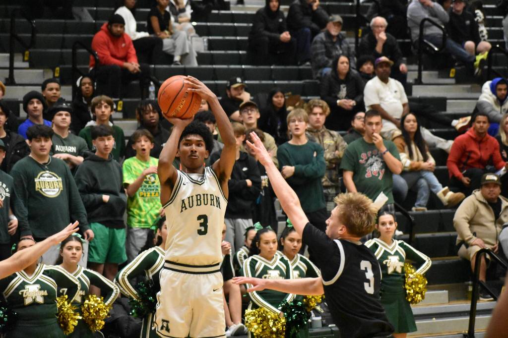 Trojan Jr. Daniel Johnson takes a three-point shot against Kentwood. Ben Ray / The Reporter