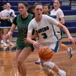 Cora Lowe fights off a Kentwood defender as she drives to the basket. Ben Ray / The Reporter