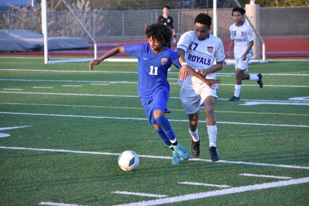 Benjamin Yitbarek fends off a Kent-Meridian player. Ben Ray / The Reporter
