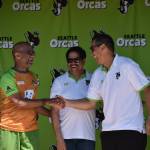 Sanjay Parthasarathy (left) and Soma Somasegar (middle) stand on stage with Seattle Orcas ambassador Ross Taylor (right). Ben Ray / The Reporter