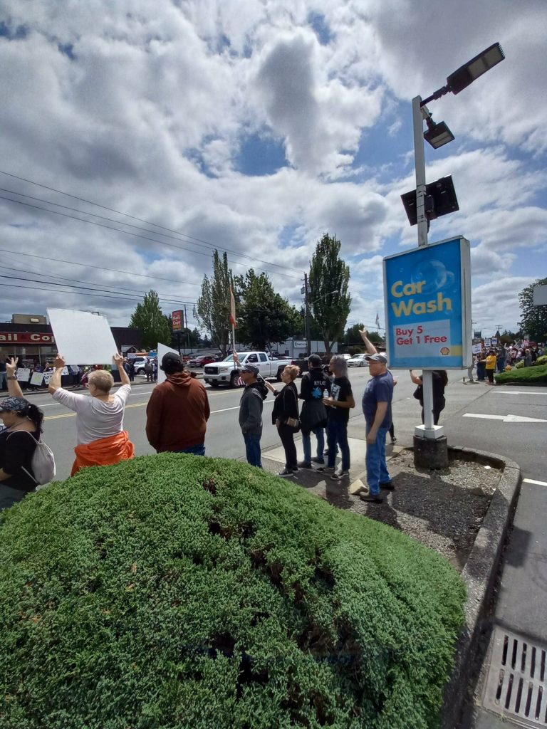 Protesters react to the many honking cars. Photo by Robert Whale/Auburn Reporter