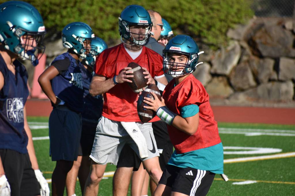 Both quarterbacks Gavin Danielson (bakground) and Colton Reeves (foreground) compete for the starting quarterback position. Ben Ray / The Reporter