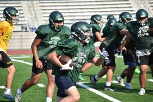 Trojan defenders chase a ball carrier at practice during a team session. Ben Ray / The Reporter