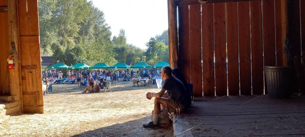 A couple contemplates the goings-on at Hops and Crops from the restored barn. Photo by Robert Whale/Auburn Reporter
