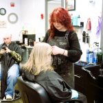 While waiting for one regular clients color to develop, Third Dimension Salon Auburn hairstylist Katie Francis trims his mothers bangs.
