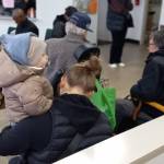 A woman and her son wait for her name to be called to the counter. Photo by Robert Whale/Auburn Reporter