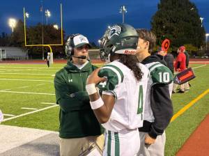 Photo by Nathan Hyun/For The Reporter
Auburn Head Coach Aaron Chantler talks to quarterback Isaiah Avelar against Mount Rainier.
