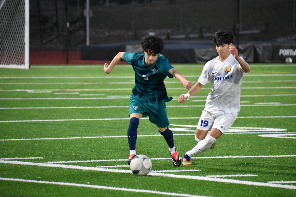 Joseph Rodriguez fends off a Tahoma player while dribbling the ball up the field. Ben Ray / The Reporter