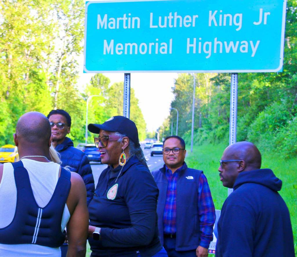 COURTESY PHOTO, Kent Black Action Commission
Gwen Allen-Carston leads a celebration May 26 of the newly installed Martin Luther King Jr. Memorial Highway sign along Benson Road in Renton.