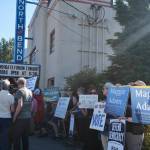 Protestors stand outside North Bend Theatre during a primary candidate forum July 14, 2026. (Grace Gorenflo/Valley Record)