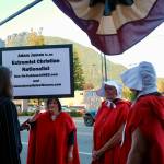 Women dressed in attire from The Handmaids Tale protest outside North Bend Theatre during a primary candidate forum July 14, 2026. (Grace Gorenflo/Valley Record)